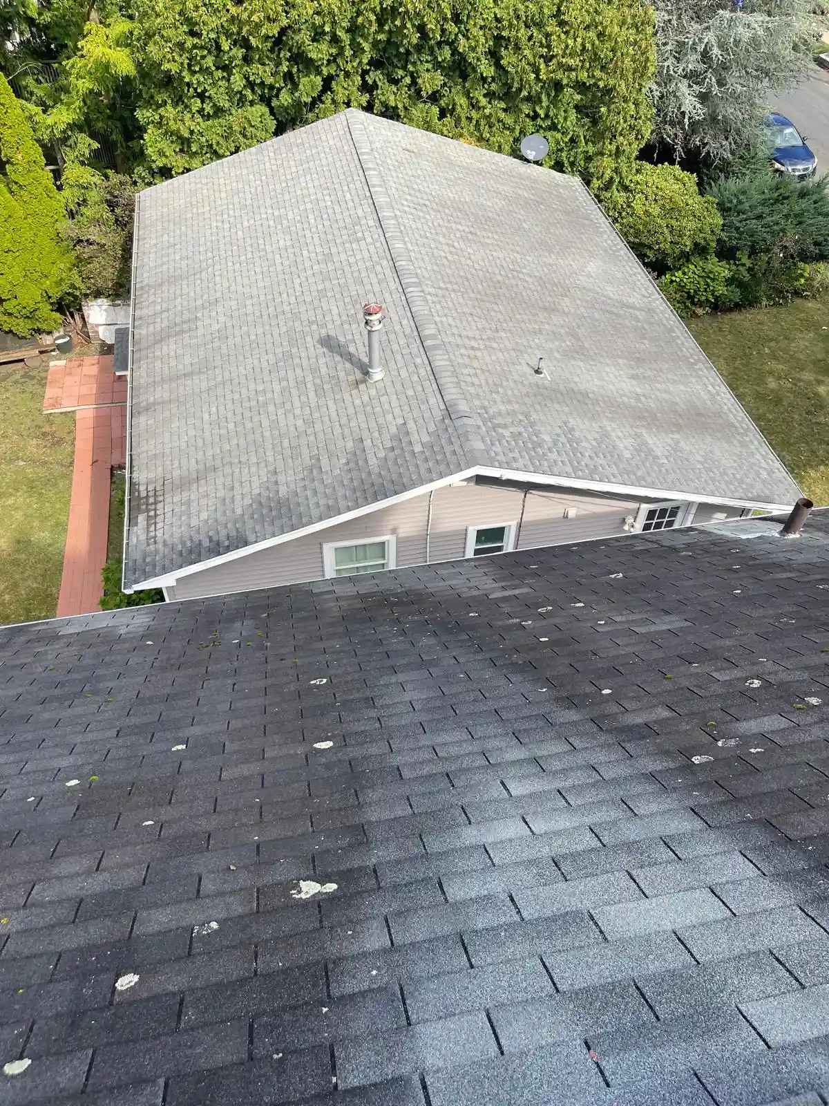 Roofer inspecting damaged shingles to decide repair or replacement